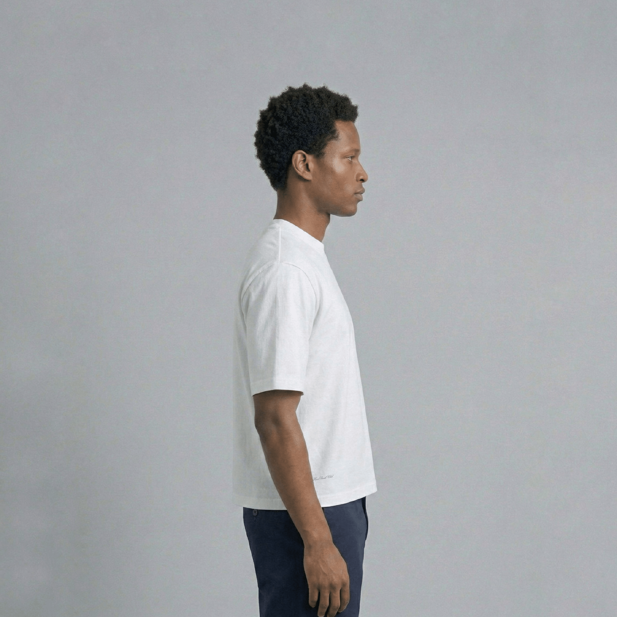 THBC Basic Tee in white, model wearing size M, side angle